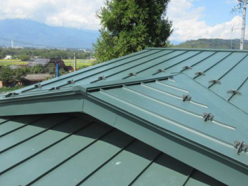 ガルバリウム鋼板立平葺きにてカバー工事が完了、さわやかなグリーン色の屋根で雨漏りの心配も払拭されました